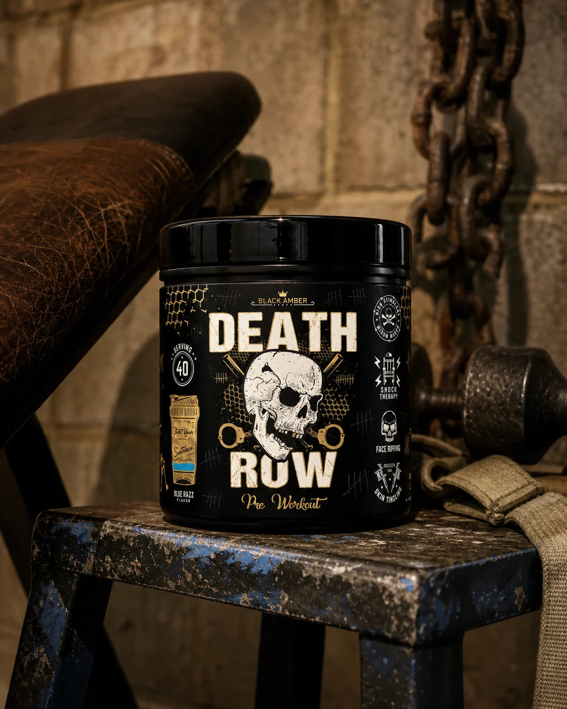 Black Amber Death Row Blue Razz pre-workout tub on a worn blue steel stand beside a gym bench and chains