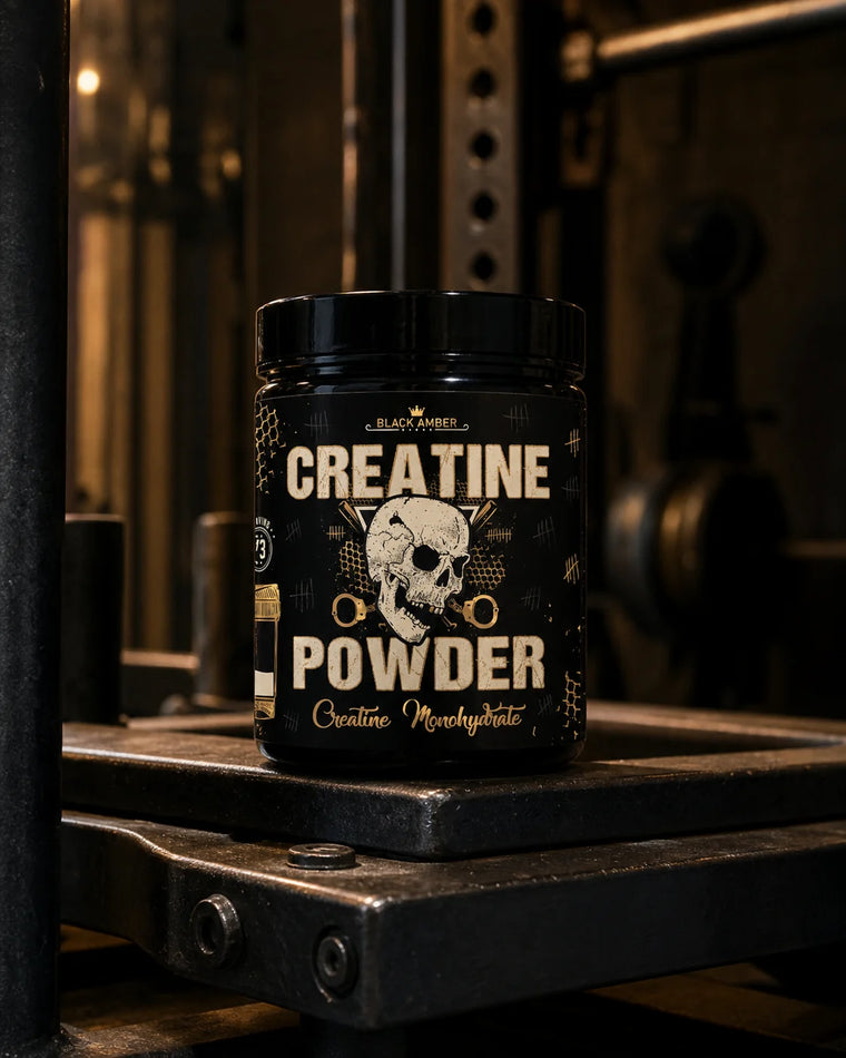 Black Amber Creatine Powder tub resting on a worn steel prowler crossbar in a dark gym