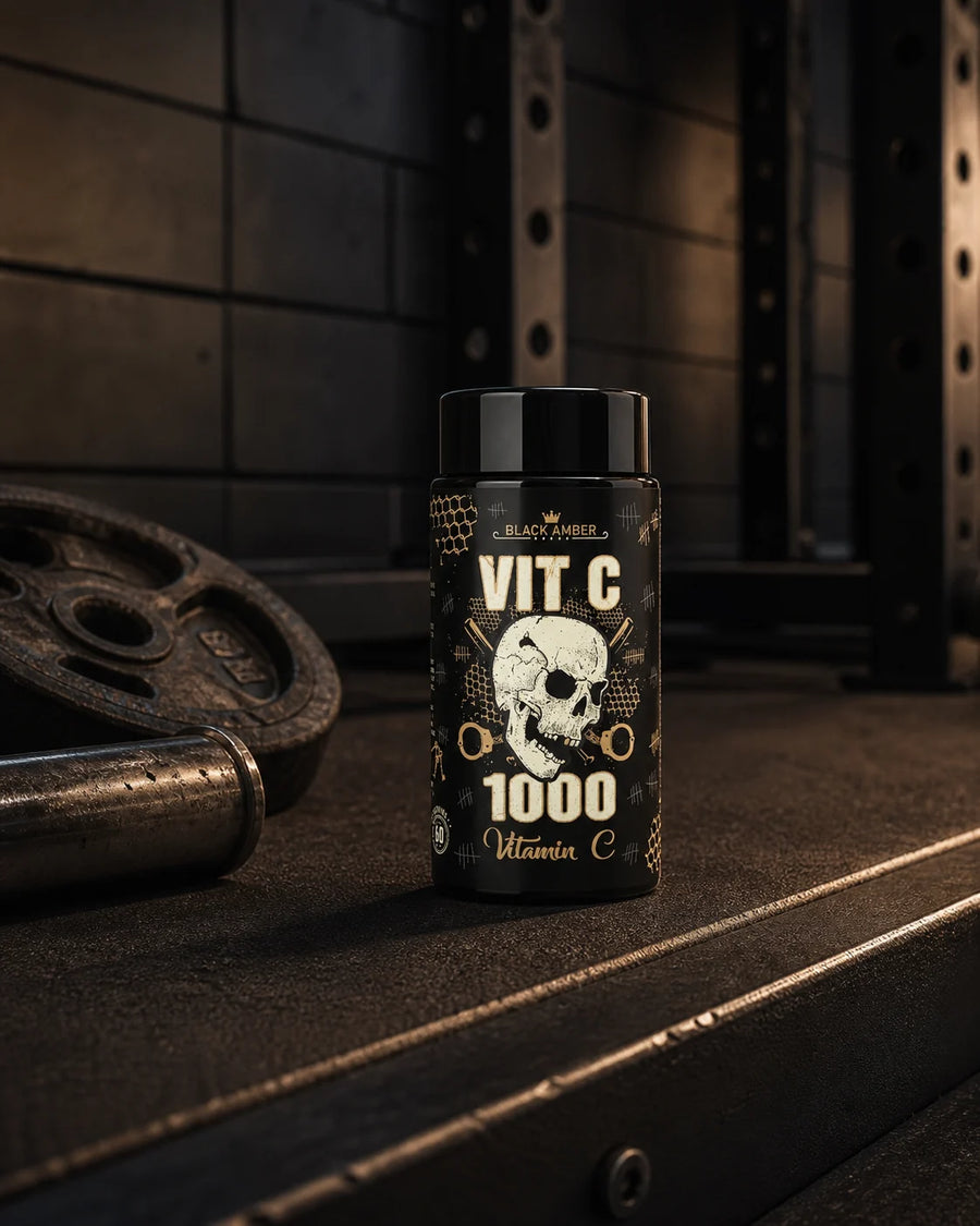 Black Amber Vitamin C 1000 bottle on a deadlift platform beside a barbell and weight plate