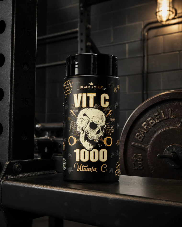 Black Amber Vitamin C 1000 bottle on a padded competition bench beside a weight plate