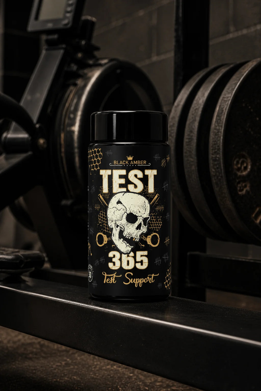 Black Amber Test 365 bottle on a dark steel training-machine rail in front of iron plates
