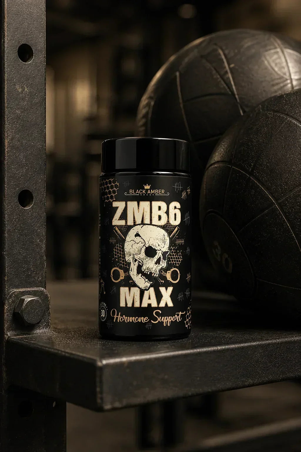 Black Amber ZMB6 Max bottle on a steel rack beside worn medicine balls