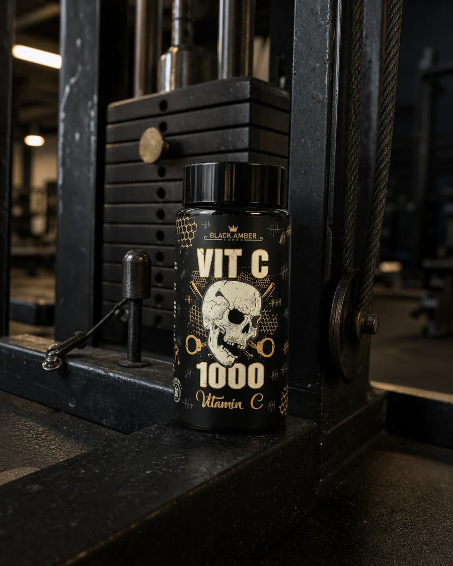 Black Amber Vitamin C 1000 bottle beside a weight stack and pulley cable in a dark gym