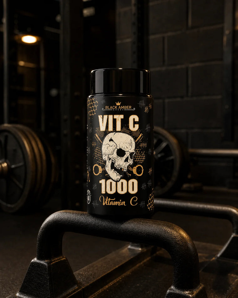 Black Amber Vitamin C 1000 bottle beside steel farmers-walk handles in a training room