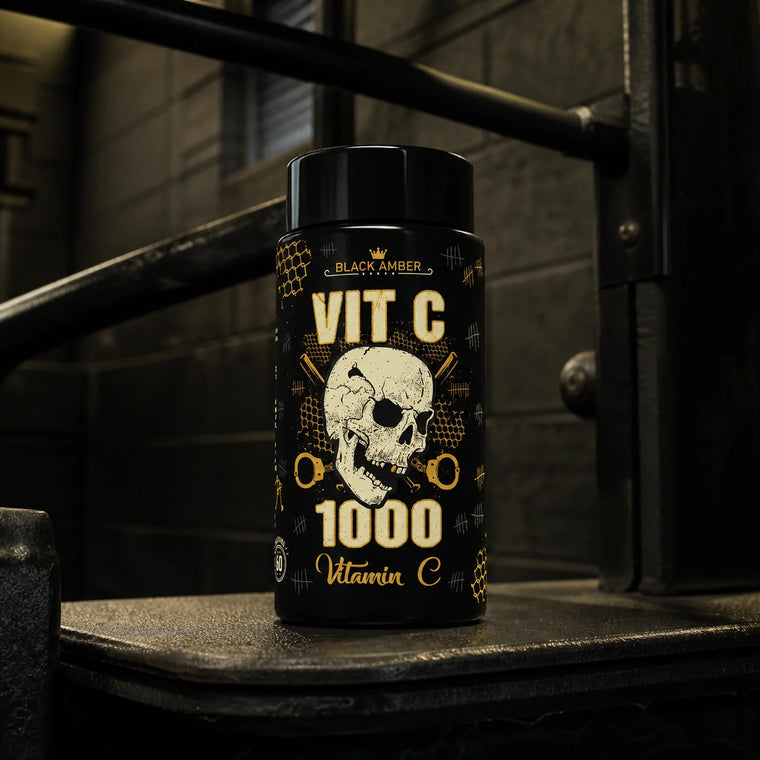 Black Amber Vitamin C 1000 bottle on a worn dip-station step in a dark industrial gym